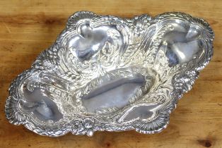 An Edwardian silver lobed oval dish with embossed decoration of leaf-scrolls & fruit, 31.5cm x 22.