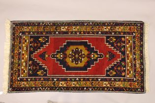 A Turkish rug of deep blue ground with central medallion to the madder field, in multiple foliate