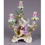 A 19th century Meissen porcelain candelabra figure of Paracelcius seated beside an oven, with three