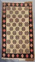 A Turkish Malatya small rug of ivory ground with repeating rows of guls in an aubergine flower-head