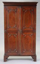 A 19th century continental mahogany cabinet with moulded cornice, later fitted with three adjustable