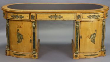 A 20th century Empire-style maple-veneered oval pedestal desk. With gilt-metal mounts and gilt-too