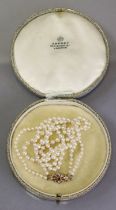 A double-row necklace of graduated cultured pearls, the largest approx. 7mm dia., the 9ct gold clasp