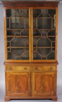 A late 19th century mahogany tall bookcase fitted three adjustable shelves enclosed by a pair of