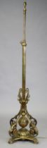 A Victorian brass standard lamp with adjustable column, foliate scrolling supports and quatre-form