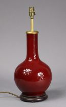 A Chinese porcelain sang-de-boeuf glazed bottle vase forming a table lamp, with un-marked white