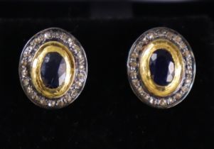 A pair of sapphire & diamond ear studs, the oval-cut sapphires set within borders of small