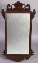 A George II mahogany wall mirror in fret-carved rectangular frame, inset bevelled plate, 112cmx61cm