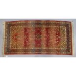 An Indian Caucasian design rug of crimson & ivory ground & having all-over repeating multi-