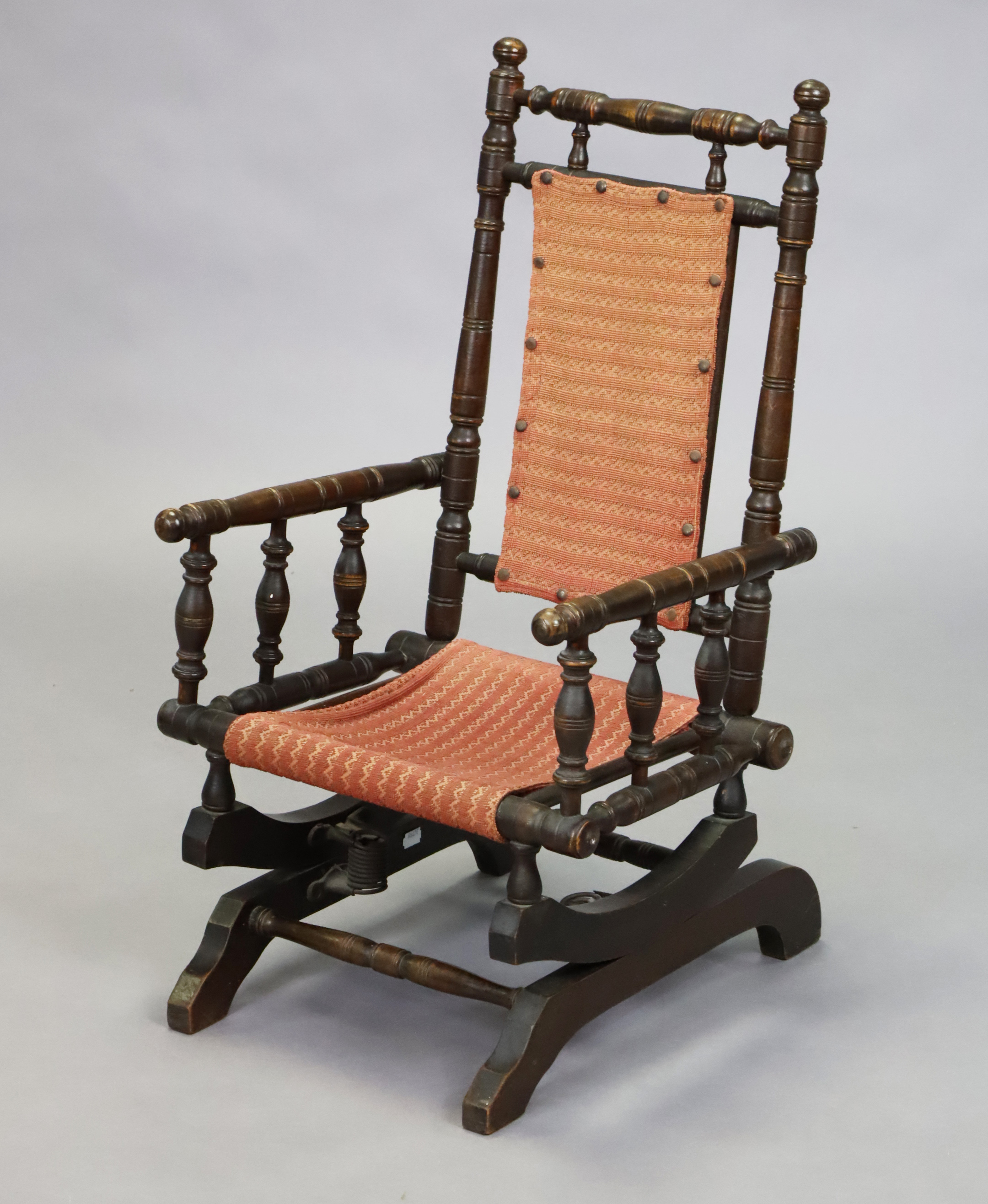 A late 19th century beech frame American-style child’s rocking chair with turned supports, loose