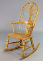 A Windsor-style splat-back rocking chair with a hard seat, & on turned supports with spindle