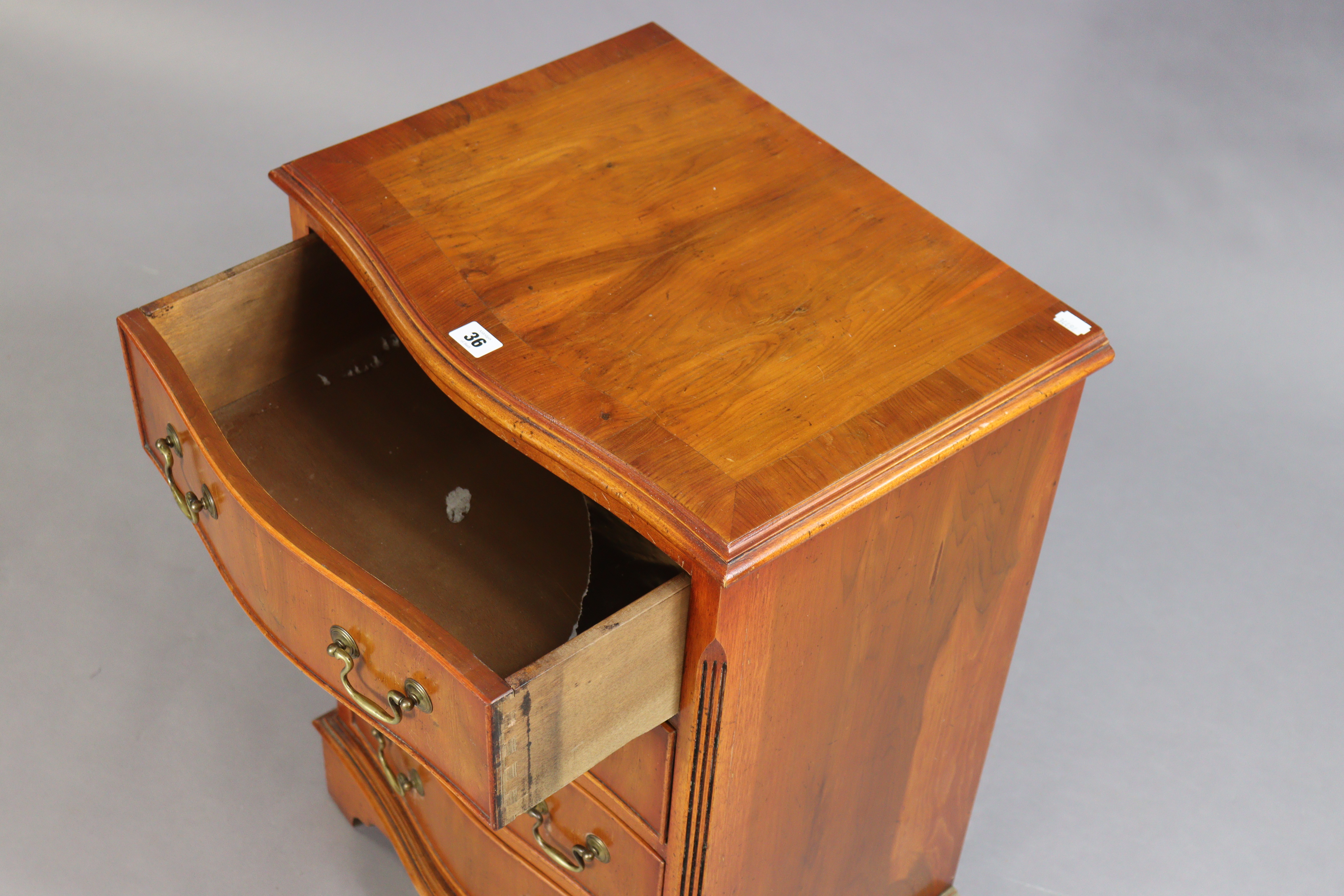 A yew wood serpentine-front bedside chest fitted four long drawers with brass swan-neck handles, & - Image 2 of 3