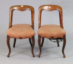 A pair of 19th century mahogany dining chairs each with an open kidney-shaped back, padded seat, &