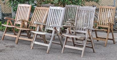 Eight teak fold-away garden elbow chairs.