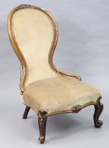 A Victorian carved walnut frame nursing chair with a padded seat & back, & on short carved