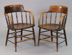 A pair of bentwood tub-shaped chairs each with a spindle-rail back, hard seat, & on turned legs with
