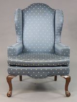 An Ethan Allen Georgian-style wing-back armchair upholstered blue & gold polka-dot material, & on