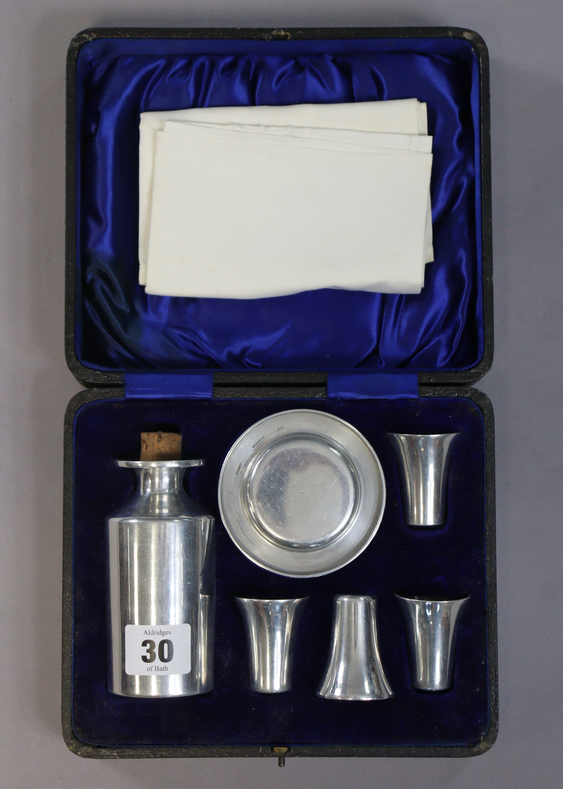 A stainless-steel seven-piece priest’s travelling communion set, with case.
