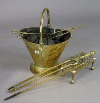 A brass helmet-shaped coal scuttle with a swing handle, 30cm high; a brass rectangular trivet; &