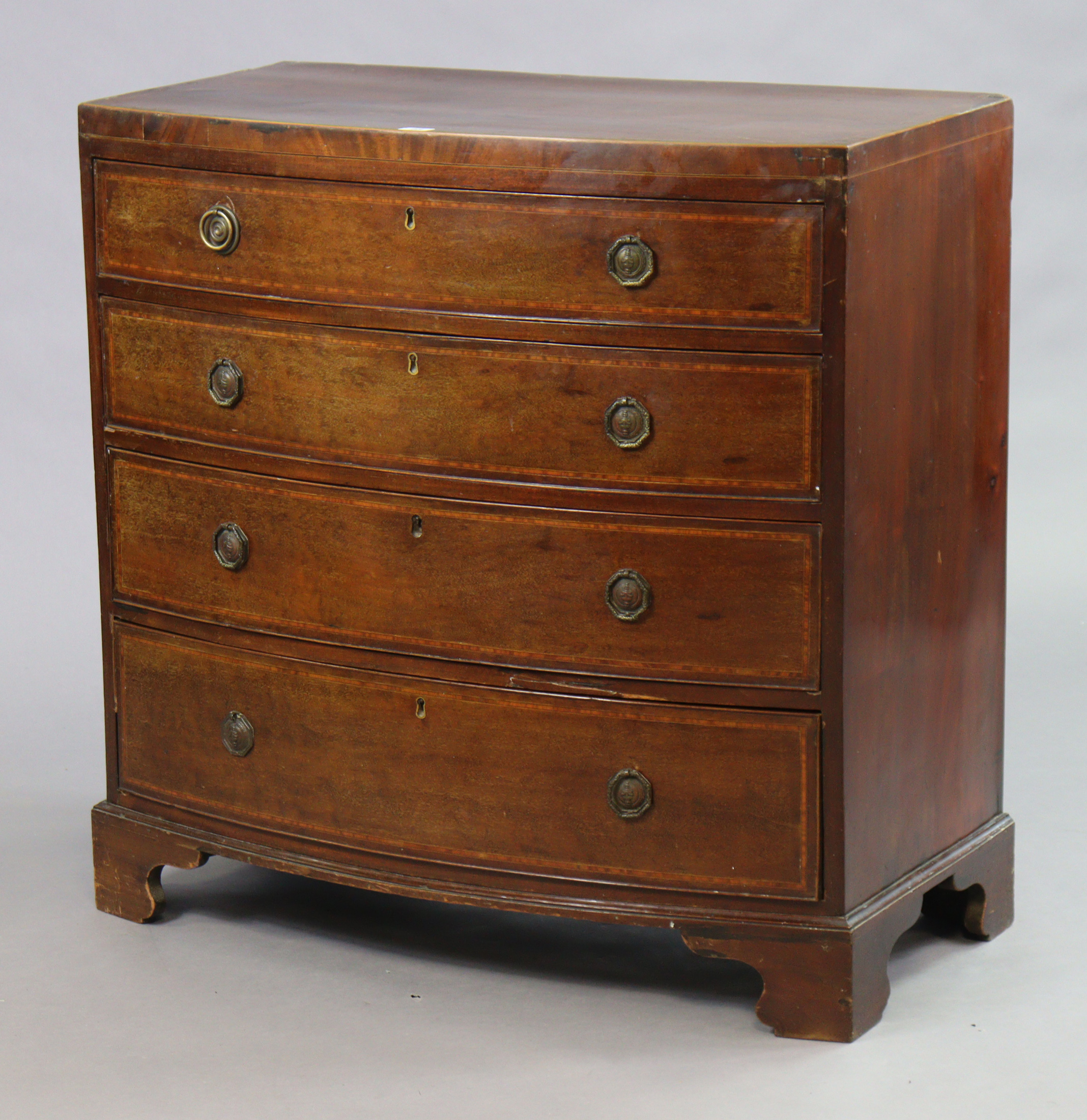 An early 19th century inlaid-mahogany small bow-front chest fitted four long graduated drawers