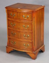 A yew wood serpentine-front bedside chest fitted four long drawers with brass swan-neck handles, &