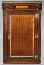 A Regency inlaid mahogany and rosewood hanging corner cupboard with gilt-metal mounts, fitted
