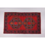 A Baluchi rug of crimson & deep blue ground, with repeating geometric design to centre within a