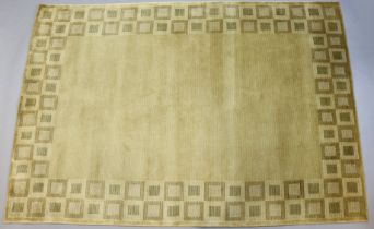 An Indian wool rug of cream/gold ground & having a chequered border (purchased from Selfridges),