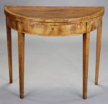 A late 18th/early 19th century inlaid mahogany demi-lune card table, inset green baize to the fold-