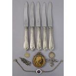 A set of five stainless-steel tea knives with loaded silver handles; together with a commemorative c