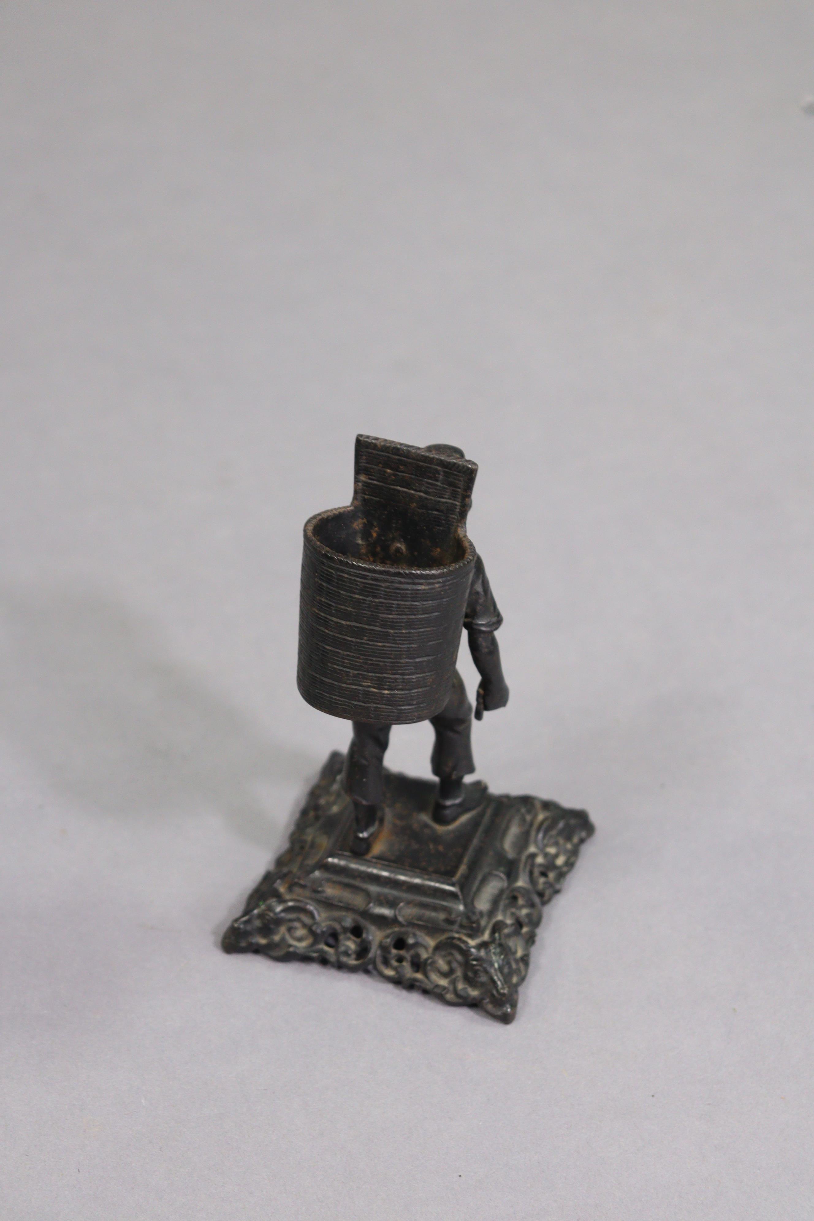 A black finish cast-metal novelty match-striker in the form of a standing male figure with a - Image 3 of 7