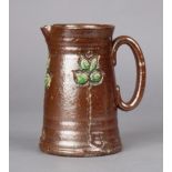 A Royal Doulton salt-glazed jug with carved foliate decoration on a chocolate-brown ground,