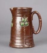 A Royal Doulton salt-glazed jug with carved foliate decoration on a chocolate-brown ground,