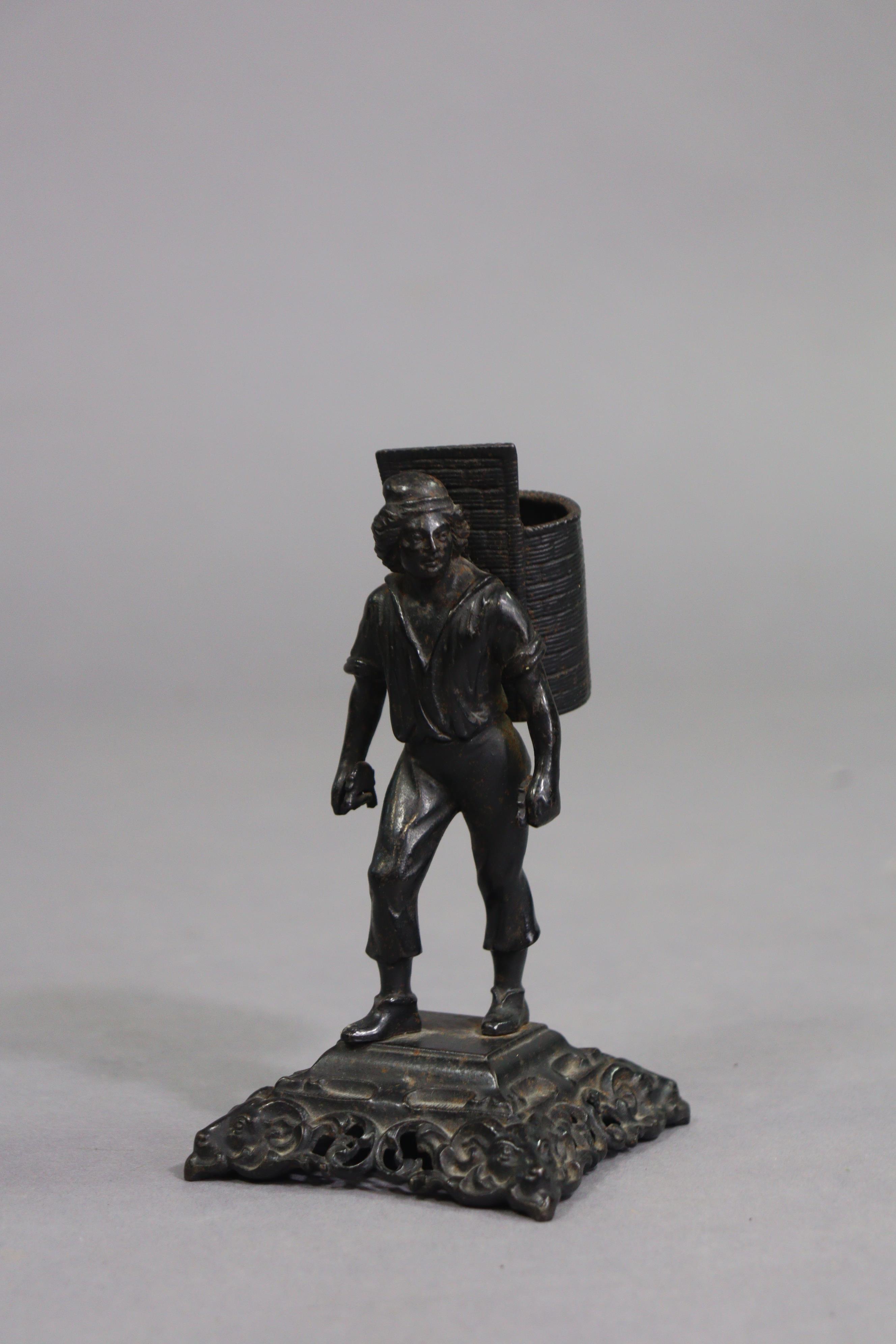 A black finish cast-metal novelty match-striker in the form of a standing male figure with a - Image 2 of 7