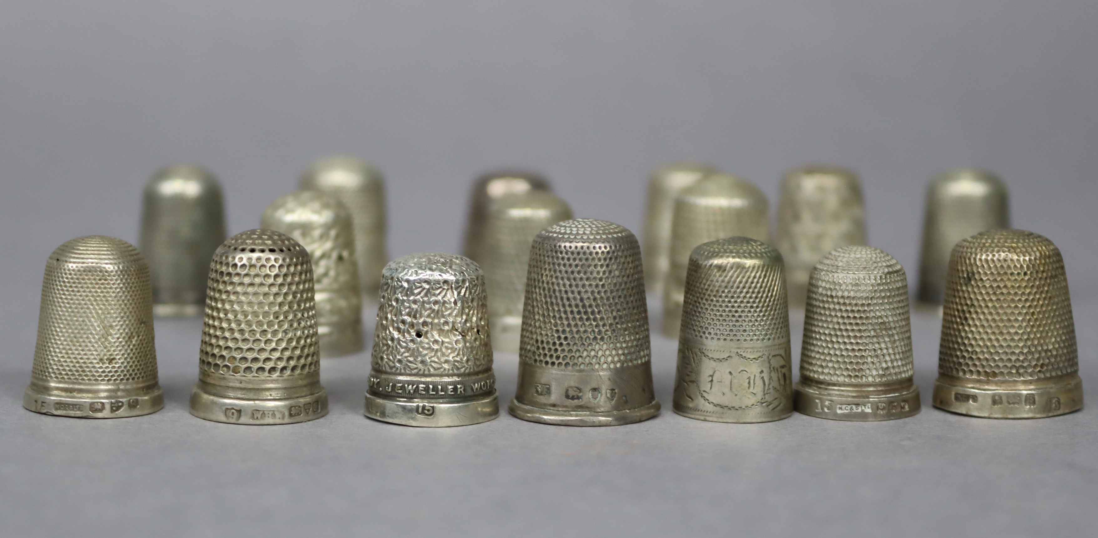 Twelve silver thimbles; & four silver plated ditto.