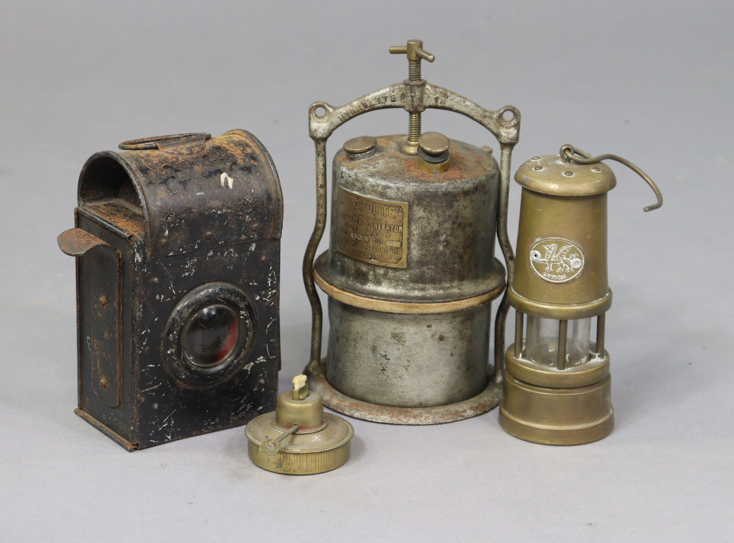 A railway lamp with burner; & two miners’ lamps.