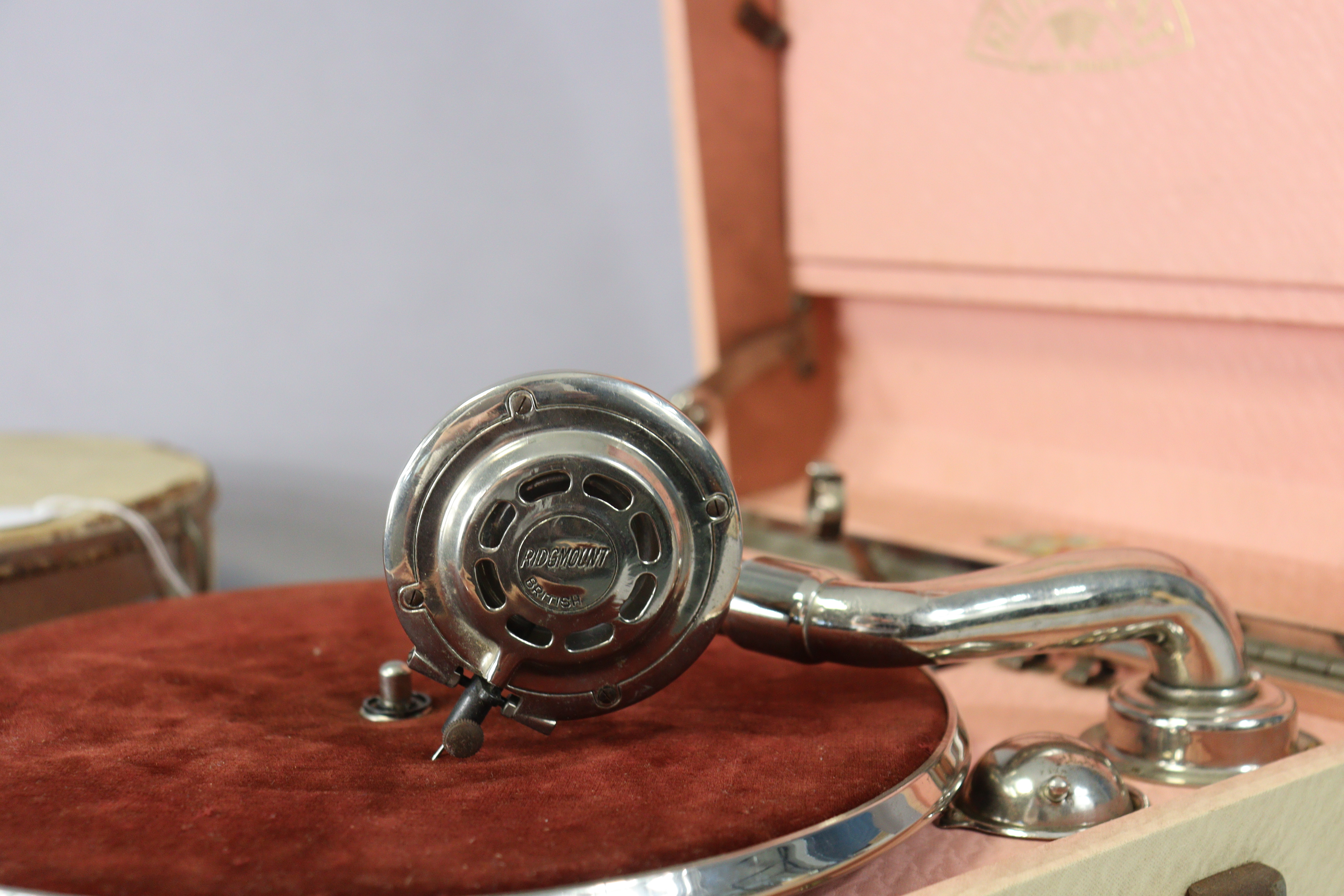 A Ridgmount portable gramophone in a cream finish fibre-covered case; together with a tambourine. - Image 2 of 7