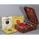 A vintage HMV portable gramophone in a red fibre-covered case; & six 78 r.p.m. records.