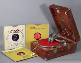 A vintage HMV portable gramophone in a red fibre-covered case; & six 78 r.p.m. records.