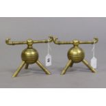 A pair of Christopher dresser-style brass firedogs each of globular ribbed form & on three supports,