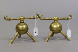 A pair of Christopher dresser-style brass firedogs each of globular ribbed form & on three supports,