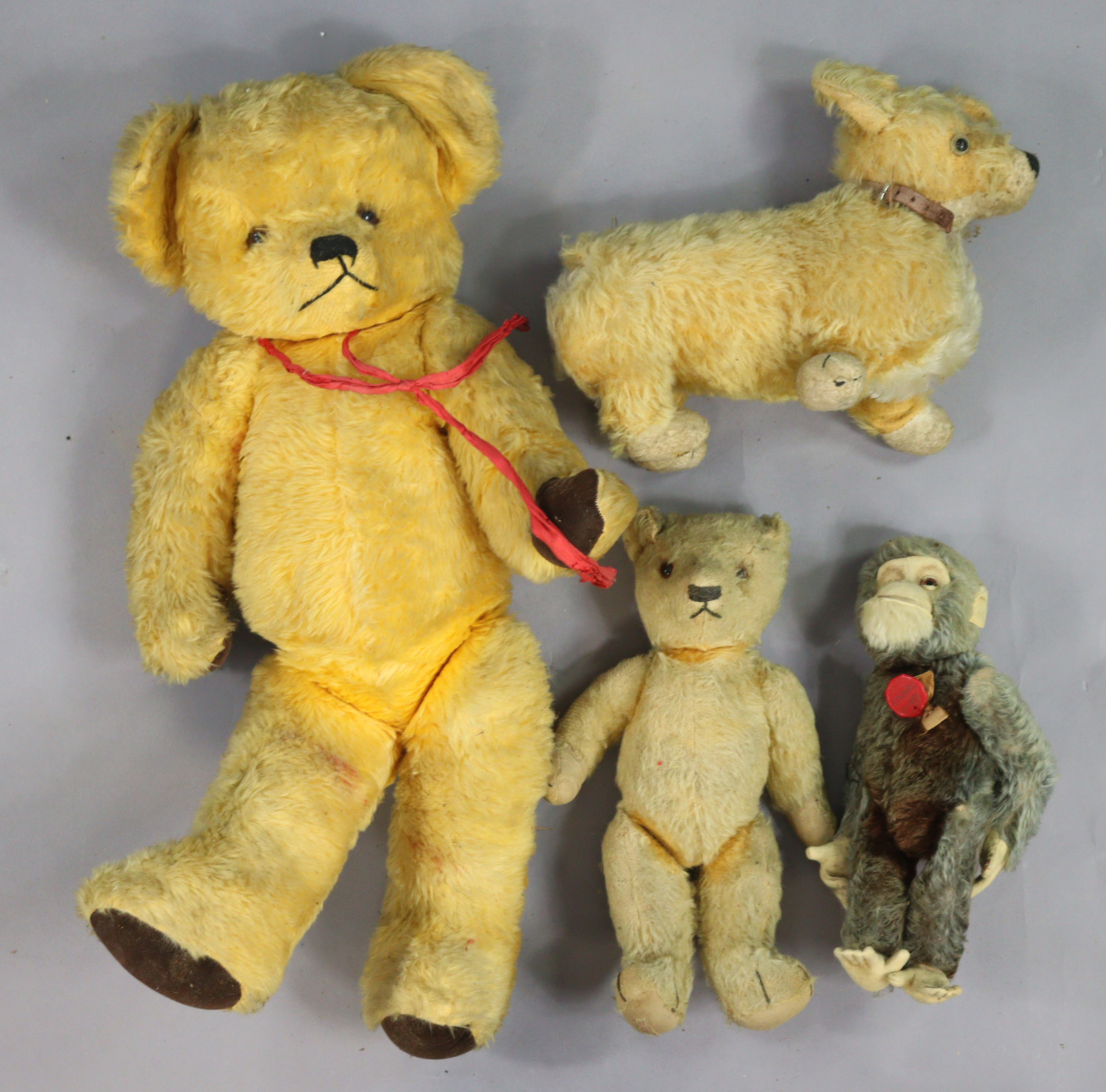 A Schuo “Tricky” monkey automaton toy, a Merrythought dog soft toy, and two golden plush teddy