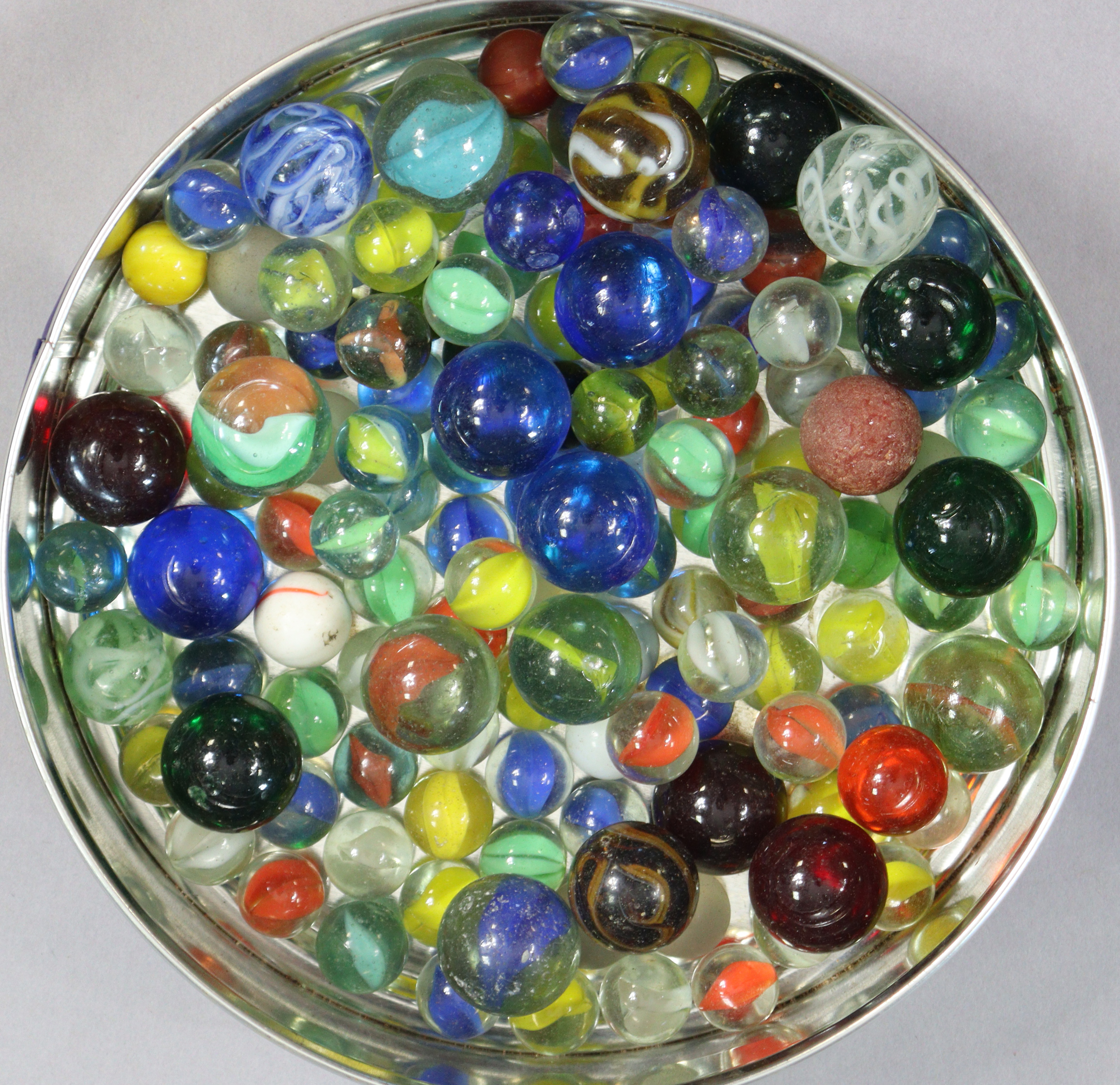 A collection of approximately eighty various glass marbles