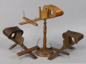 Three vintage wooden stereo-card viewers, on with a stand.