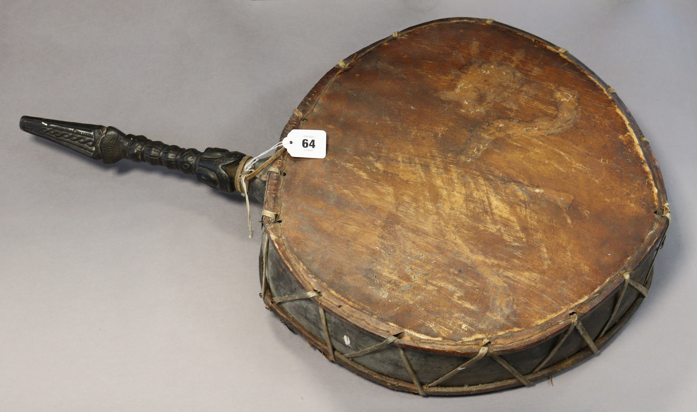 A Nepalese shaman’s drum or Dhyango having an ebonised & carved wooden handle, 44cm diameter x