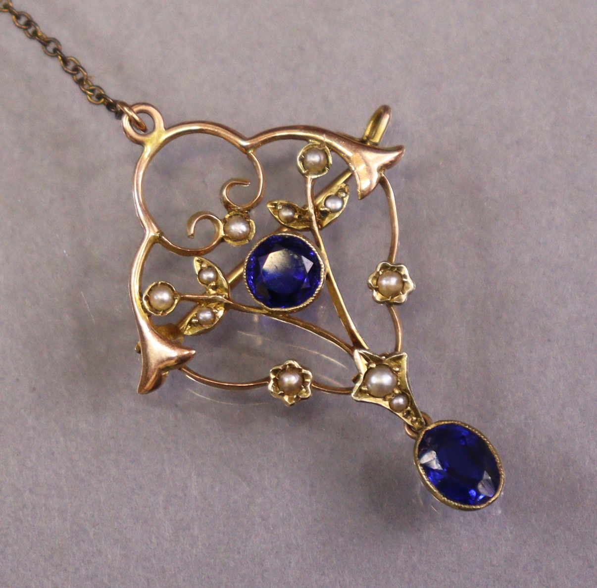 An early 20th century 9ct gold openwork brooch set round-cut sapphire & seed pearls, an oval-cut