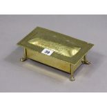 An arts & crafts-style brass rectangular trinket box with an engraved boars-head to the hinged