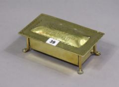 An arts & crafts-style brass rectangular trinket box with an engraved boars-head to the hinged