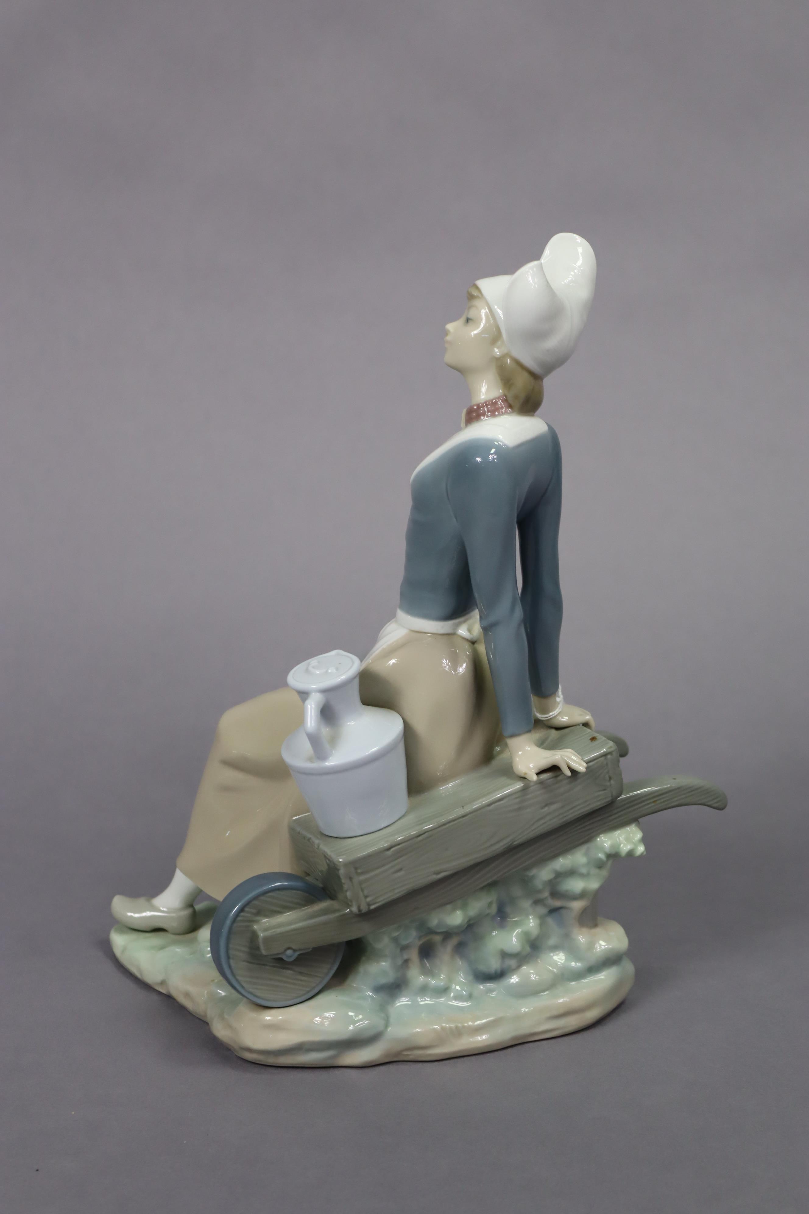 A Lladro porcelain figure of a milkmaid seated on a wheelbarrow, 32.5cm high. - Image 4 of 7