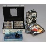 Twenty various James Bond DVDs; a set of 007 spy cards, both cased; & various James Bond books &